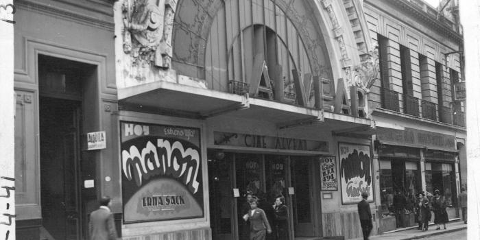 En blanco y negro la imagen de una acera antigua con una fachada de cine